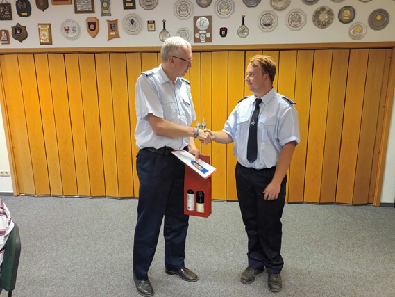 Kreisjugendfeuerwehrwart Stefan Kothe (links) bedankt sich bei Benjamin Stichling für die geleistete Arbeit als Fachbereichleiter Jugendforum und überreicht die Abberufungsurkunde sowie ein Dankeschöngeschenk.