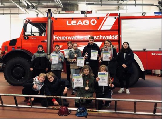 Gruppenbild in der Fahrzeughalle der LEAG Werkfeuerwehr am Standort Jänschwalde alle Teilnehmer des Amtes Döbern-Land