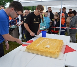 Anschnitt einer der Geburtstagstorten durch Kreis&shy;jugend&shy;feuerwehrwart Chritsian Rösiger (hinten) und dem Vorsitzenden des Kreisfeúerwehrverbandes Spree-Neiße e.V. Robert Buder (vorn)