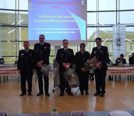 Neuer Kreis&shy;jugend&shy;feuerwehrwart Spree-Neiße, Christian Rösiger (Mitte) eingerahmt von seinen Stellvertretern Carolin Vatter (links) und Stefan Kothe (rechts) sowie dem Vorsitzenden des Kreis&shy;feuerwehr&shy;verbandes Spree-Neiße e.V. (links außen) und dem abgelösten amt. Kreis&shy;jugend&shy;feuerwehrwart Robert Buder (rechts außen).