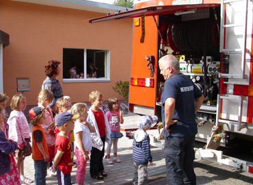 Herr Grunewald, mit den Kindern der Kita und des Hortes am Tanklöschfahrzeug.