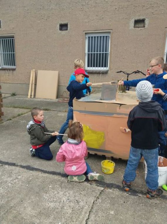 Die Kinder beim Basteln und Bemalen des Hauses