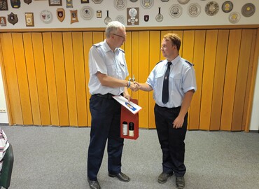 Kreisjugendfeuerwehrwart Stefan Kothe (links) bedankt sich bei Benjamin Stichling für die geleistete Arbeit als Fachbereichleiter Jugendforum und überreicht die Abberufungsurkunde sowie ein Dankeschöngeschenk.