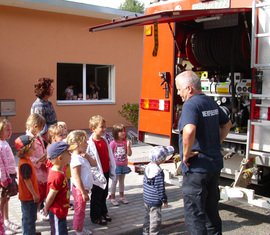 Herr Grunewald, mit den Kindern der Kita und des Hortes am Tanklöschfahrzeug.