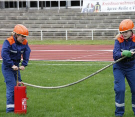 Gruppenstafette der Pokaldisziplinen - Wettbewerber 3 und 5 spritzen gemeinsam die Zielgestände von den Pfählen