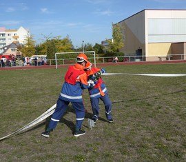 Zwei Jugendfeuerwehrmitglieder kuppeln bei der Schnelligkeitsübung zwei C-Schläuche zusammen